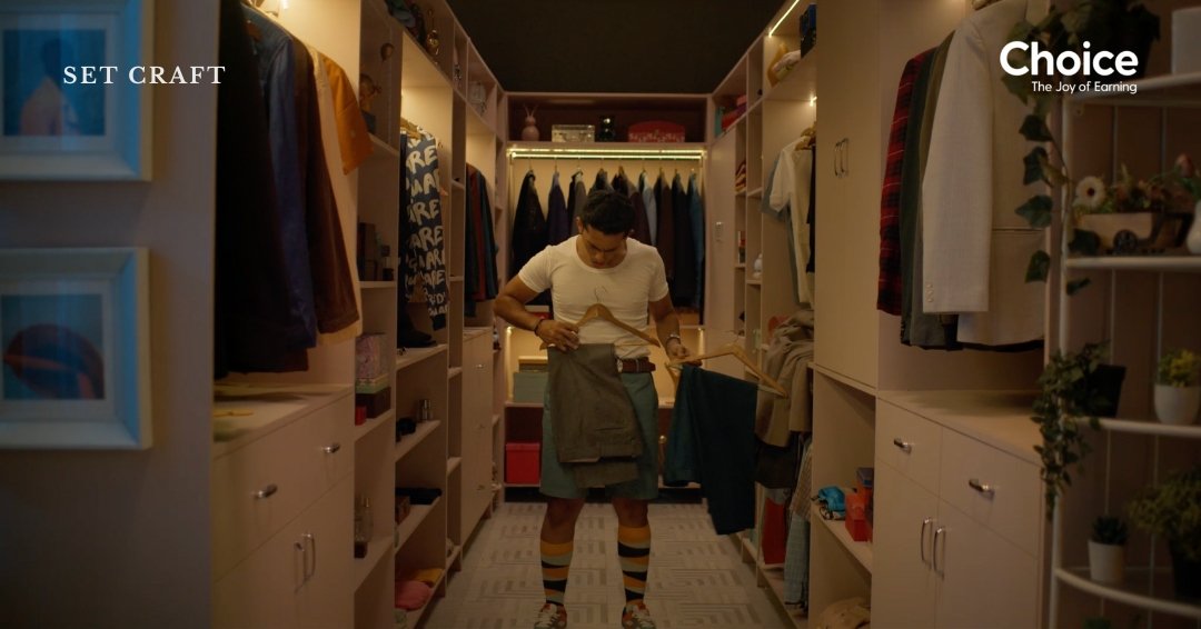 Walk-in closet set design for Choice Finx advertisement showing symmetrical wardrobe layout and neutral interior tones