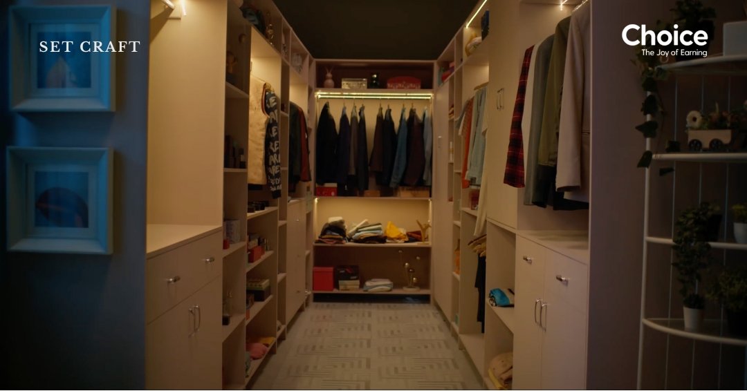 Minimal walk-in closet interior set design for advertisement film with organized wardrobes and neutral palette