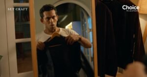 Mirror shot inside walk-in closet set showing wardrobe selection moment in advertisement film