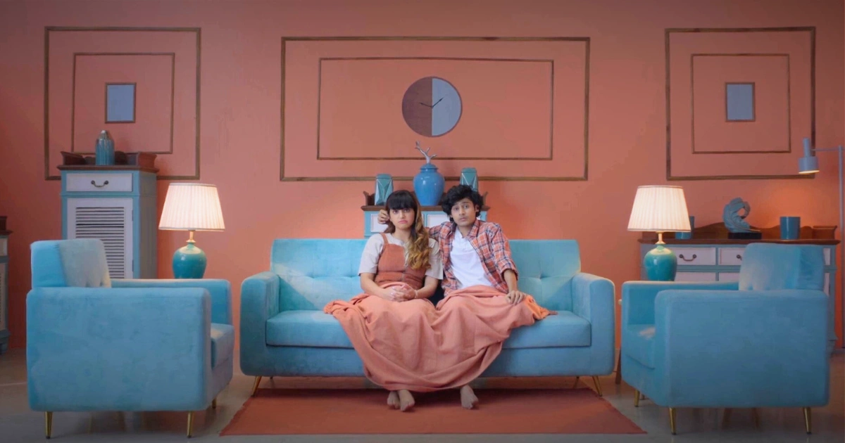 Production design for an advertising film featuring a symmetrical living room set with coral walls and teal furniture, designed by Set Craft in Mumbai