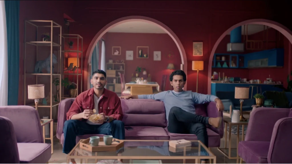 Burgundy living room set with arched architecture, purple sofas, and cinematic television commercial styling.