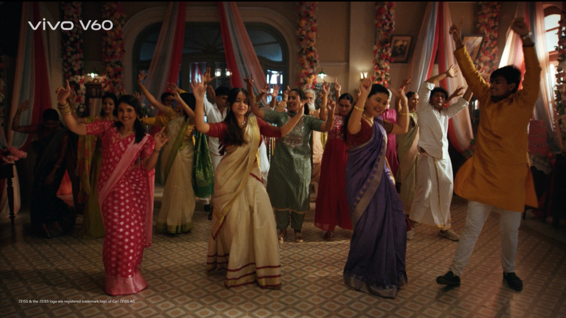 Festive dance floor setup with colorful drapes, floral decor and warm celebration lighting for a commercial shoot.