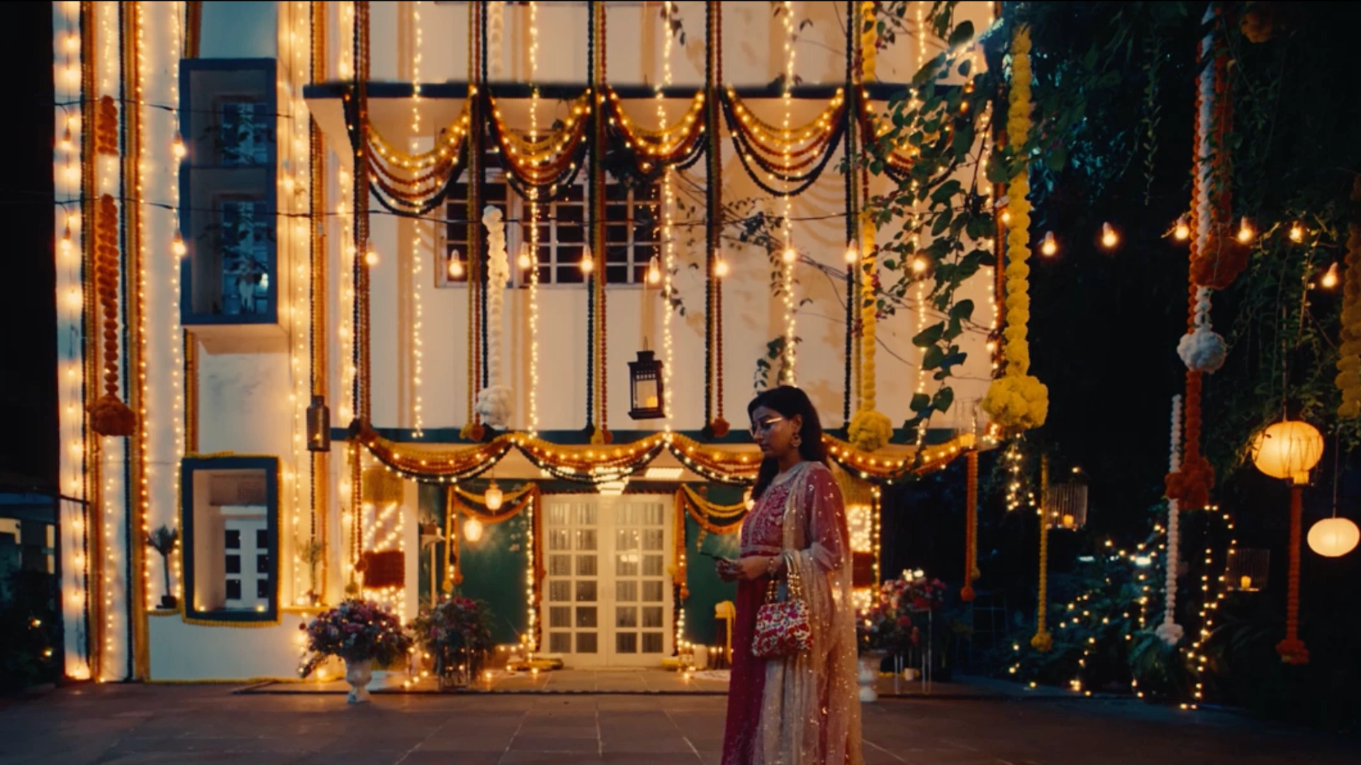Decorated festive house exterior with fairy lights, garlands and warm evening ambience designed by Set Craft.