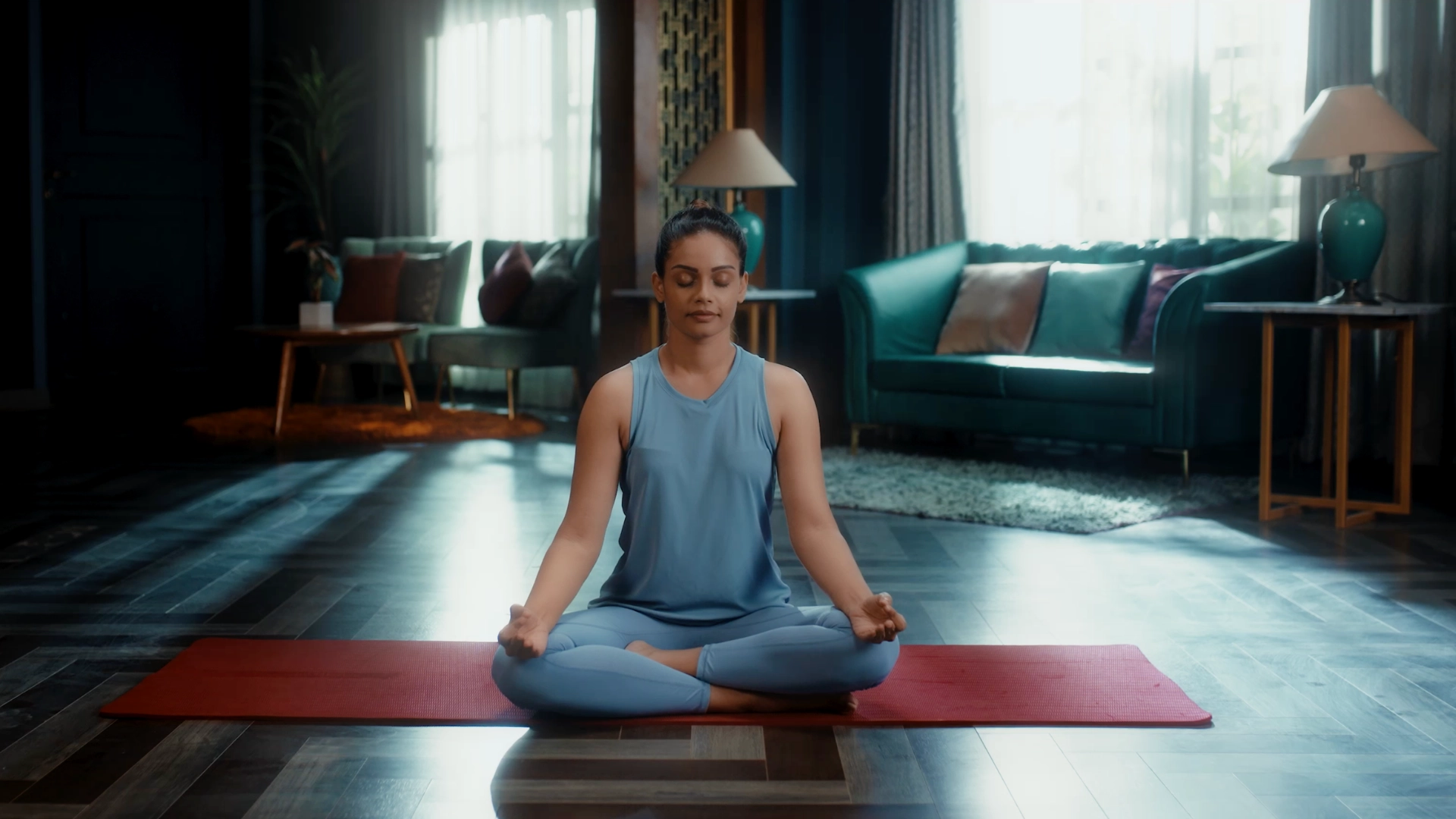 Luxury yoga and meditation room setup with teal sofas, cinematic daylight and wellness-inspired interior styling.