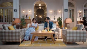 Modern family living room set with plaid sofas, warm ambient lighting and symmetrical interior styling for an ad film.