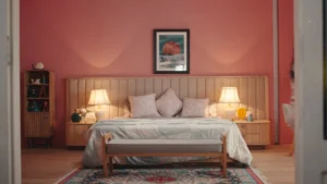 Pastel pink bedroom set with upholstered headboard, warm bedside lamps, and cinematic interior styling.