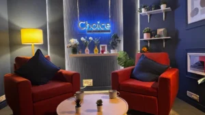 Cinematic soundproof YouTube and podcast studio interior designed by Set Craft with orange lounge chairs and blue acoustic walls