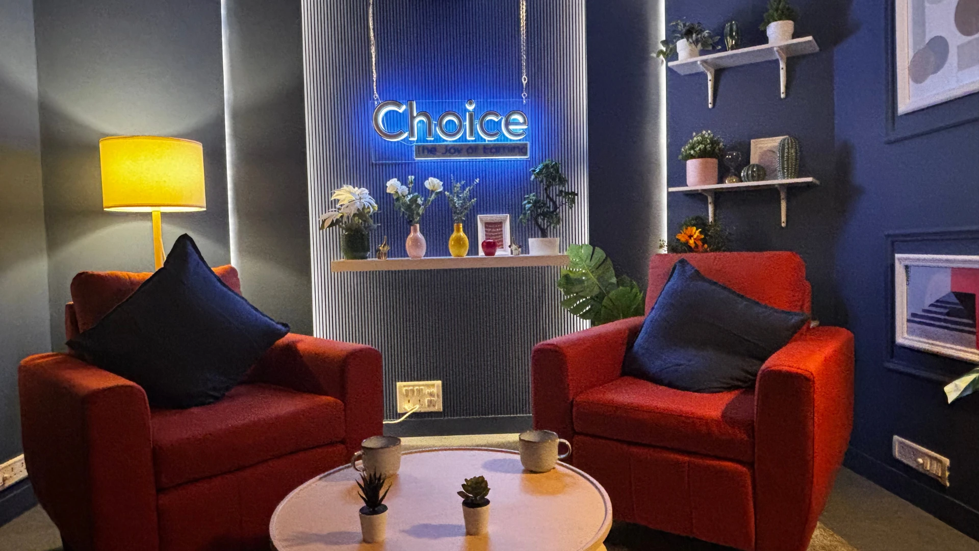 Cinematic soundproof YouTube and podcast studio interior designed by Set Craft with orange lounge chairs and blue acoustic walls