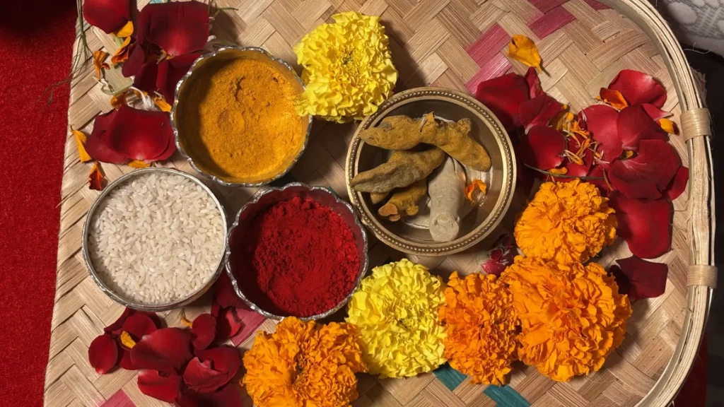 Close-up of turmeric, vermilion, rice and marigold flowers used in Bengali wedding rituals.