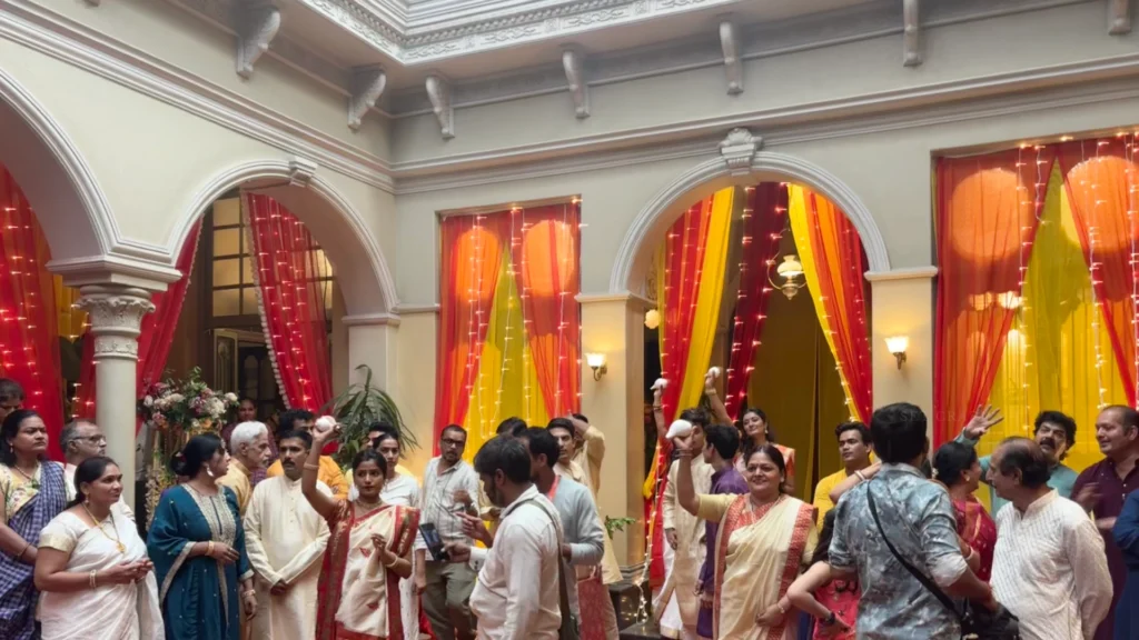 Family members and performers gathered inside a Bengali wedding set prepared for filming.