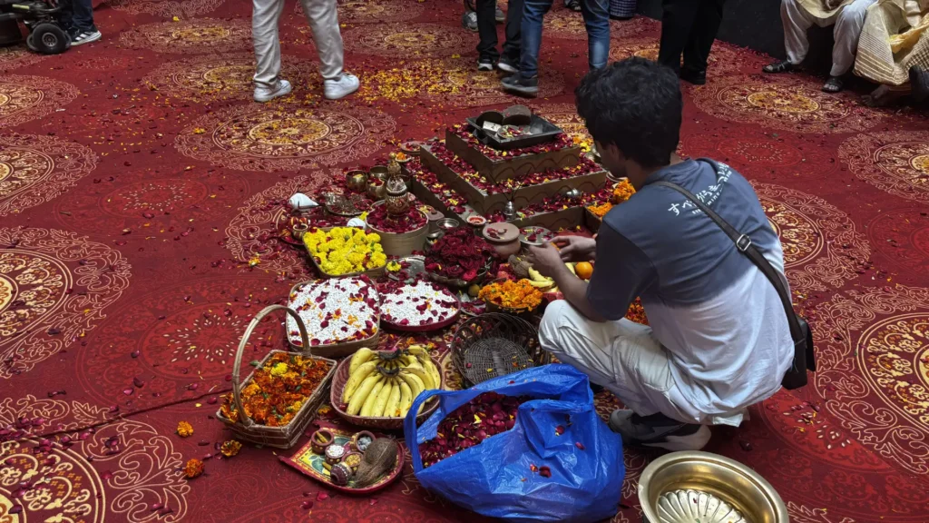 Production design team arranging ceremonial offerings, flowers and ritual decor before filming.