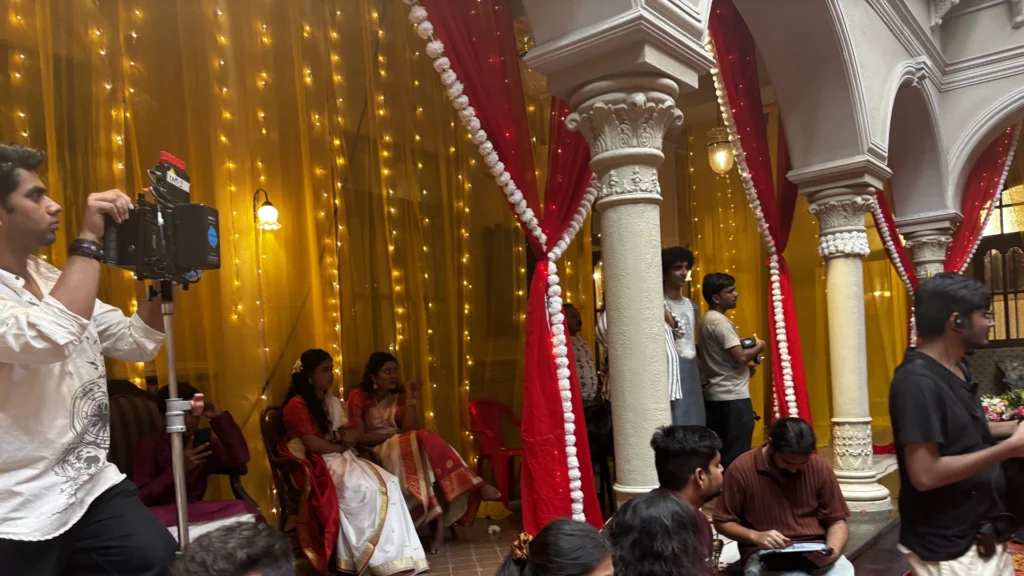 Crew members installing drapery, lighting and decorative elements for a Bengali wedding film set.