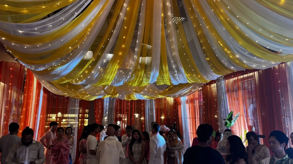 Wide view of the completed wedding set showcasing fabric drapery, lighting, and spatial styling.
