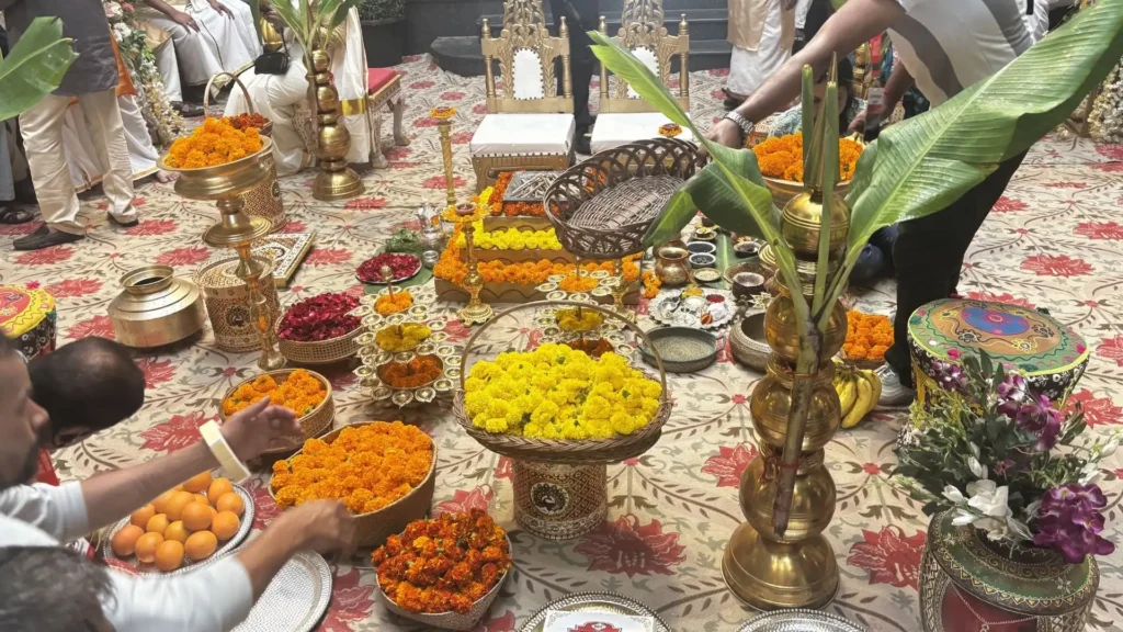 Traditional Indian wedding ritual setup featuring brass décor, floral arrangements, banana leaves and ceremonial accessories.