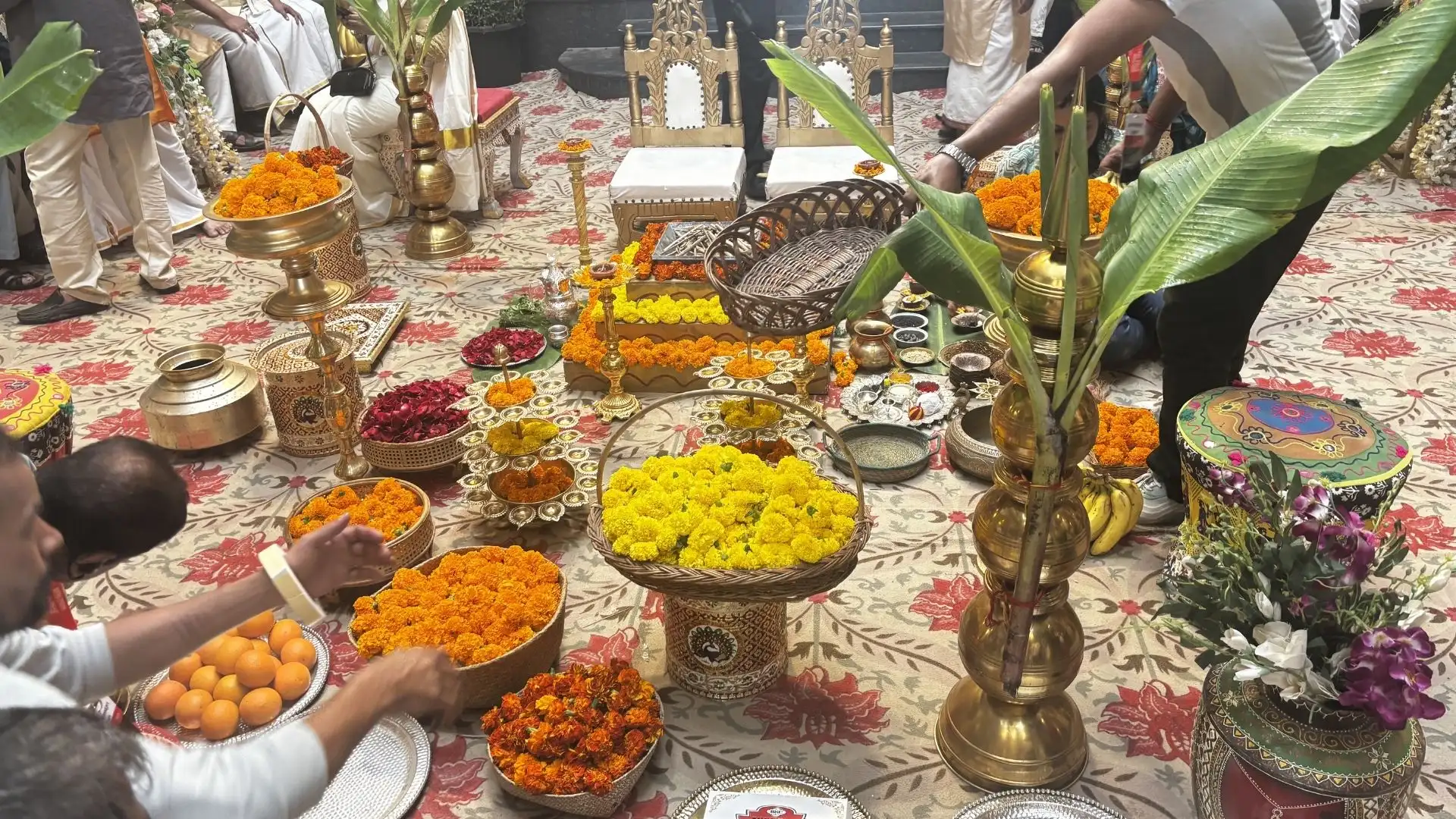 Traditional Indian wedding ritual setup featuring brass décor, floral arrangements, banana leaves and ceremonial accessories.