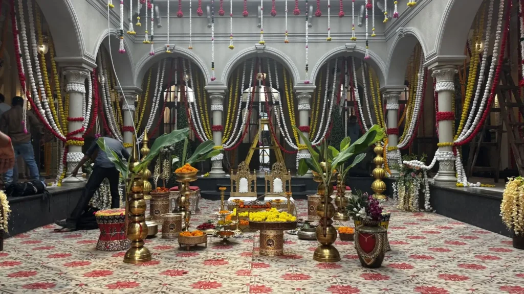 Completed South Indian wedding set featuring floral garlands, brass décor and ceremonial arrangements before filming begins.