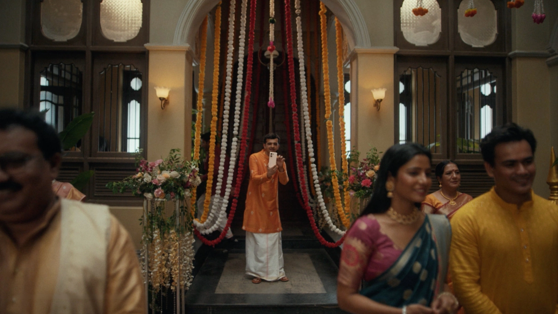 Guests arriving inside a heritage courtyard decorated with floral installations and traditional wedding décor.