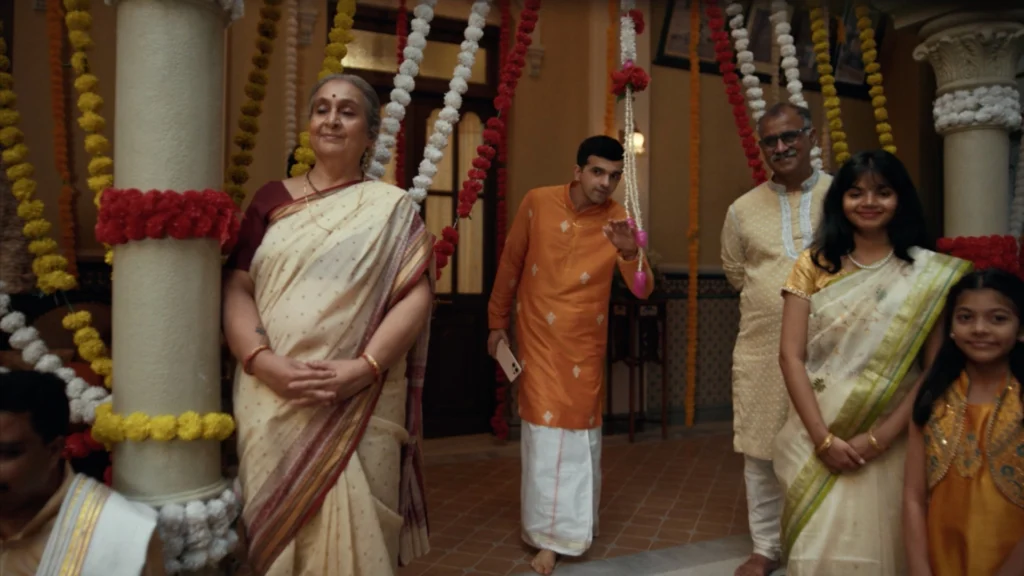Family members watching a traditional wedding ceremony inside a heritage courtyard decorated with floral installations.