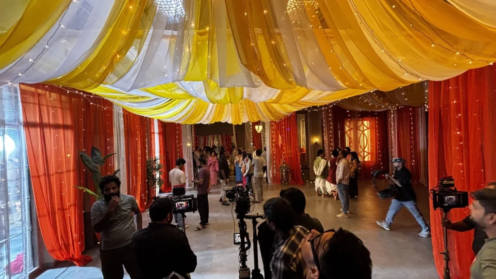 Film crew preparing cameras and equipment inside the Manipuri wedding set.